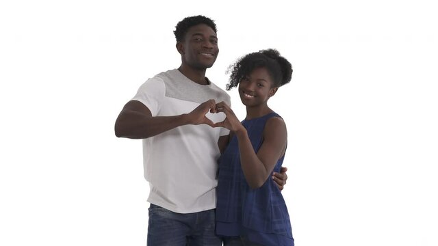 Portrait of hugging black couple doing together hand heart gesture by curling index fingers on each hand with the thumbs pointing down and join them to make a heart shape isolated on white background