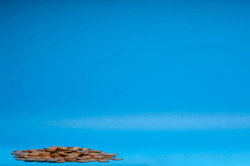 Small pile of coins isolated on blue background.