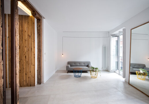 Simple interior of modern living room with wooden doors and white walls