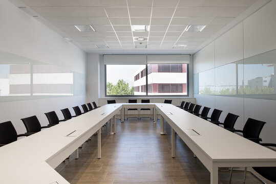 Interior of modern office with table and chairs located in room with white walls