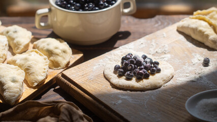 Cooking homemade blueberry dumplings. Ready dumplings and ingredients
