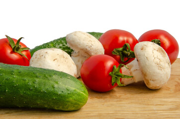 Tomatoes cucumbers mushrooms. Fresh vegetables and mushrooms on a white background.