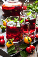 Glass cups and tea pot with berry  tea  on  wooden  background
