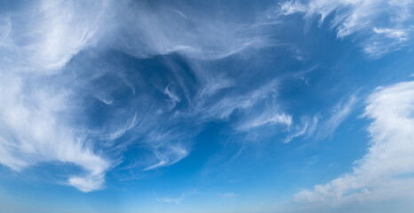 White cirrus fuzzy clouds in blue azure sky. Summer good weather panorama background.