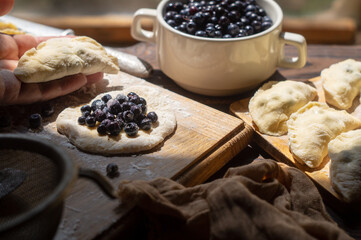 Cooking homemade blueberry dumplings. Ready dumplings and ingredients