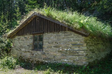 Stone cottage with a grass roof in the forest located in western Sweden