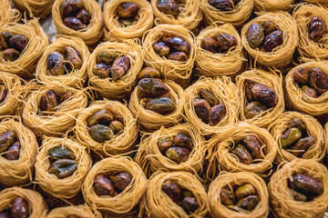 Plate with type of Arabic sweets with pistachio nuts called taj el malak in sweet shop in Lebanon
