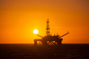 Fototapeta na wymiar Oil rig at sunset time