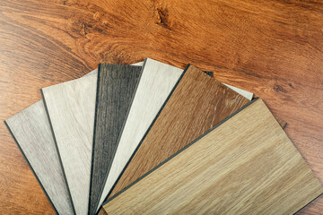 Obraz na płótnie Canvas Laminate background. Samples of laminate or parquet with a pattern and wood texture for flooring and interior design. Production of wooden floors