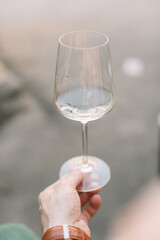 Man holding glass of wine outdoors.