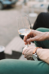 Man holding glass of wine and relaxing on the terrace in the city.