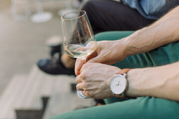 Man holding glass of wine and relaxing on the terrace in the city
