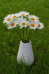 the bouquet of white daisies in a white vase 