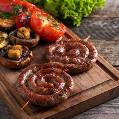 Sausages cooked on a grill with vegetables