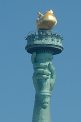Close image of statue of liberty flame in a sunny day with pure blue sky
