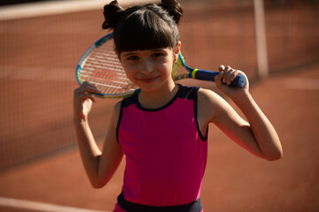 portrait of a cute girl and wearing her tennis racket behind her head