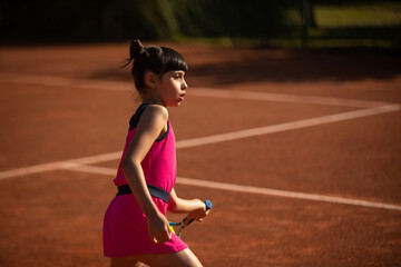 girl concentrated on tennis court and playing tennis
