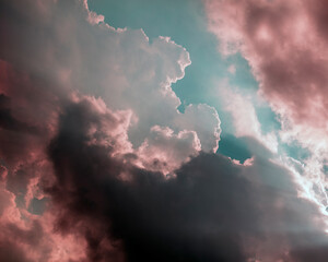 Dramatic sky with storm clouds and sunny clouds clashing against each other producing vivid tones and deep contrast textures. Change of weather environment climate. 