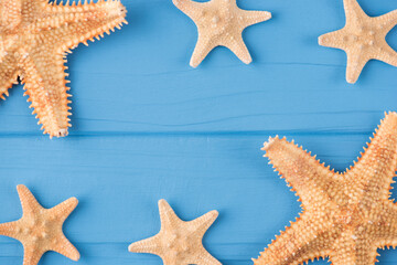 Top above overhead view close-up photo of starfish isolated on blue wooden background with copyspace
