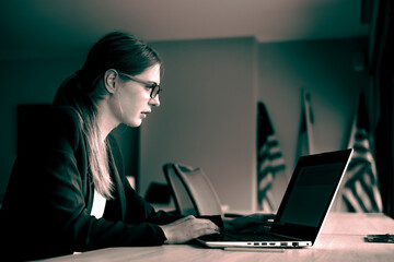 Business girl in glasses with a laptop sitting in front of the window. Development of women's business