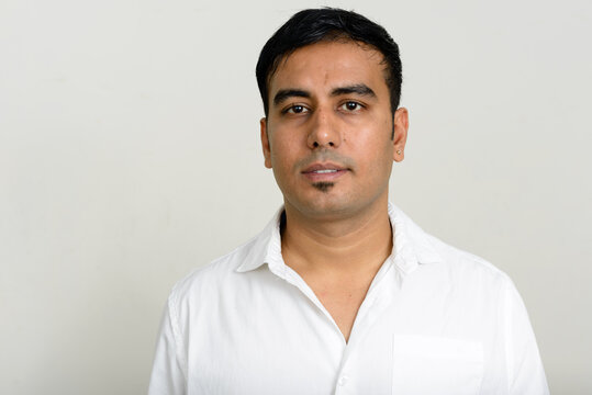 Portrait of handsome Indian businessman against white background