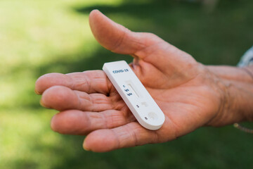 Elderly person with a rapid test or diagnostic test for Covid-19 or sars-cov-2 in the palm of the hand. This test measures igg and igm to obtain the result using antibodies.