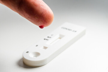 Person taking a quick test or diagnostic test to detect Covid-19 or SARS-CoV-2 in humans. By drop blood on your finger.  Detects igg and igm by obtaining antibodies.
