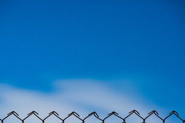Wire fence and blue sky background