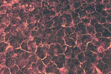 Obraz premium Glowing Lava Rock Texture with strong contrast black and orange tones, depicting drought, chaos and a hot, hellish environment
