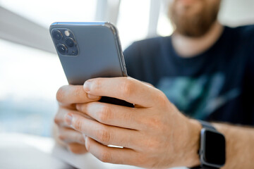 man texting with both hands on phone closeup 