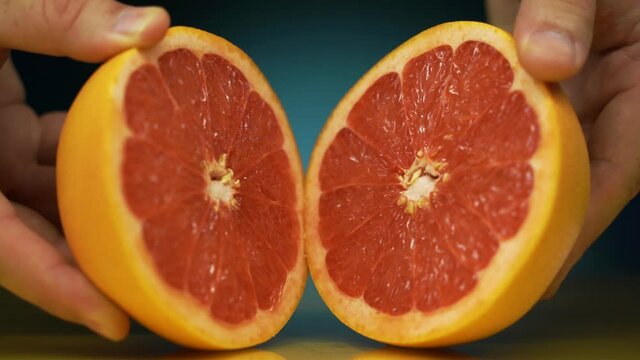 pink grapefruit cut in half. Ripe half of pink grapefruit citrus fruit, sliced grapefruit on blue background,