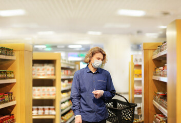 Supermarket shopping, face mask and gloves,Young man shopping in supermarket, reading product information
