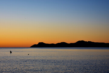 Sunrise over palma de port de pollensa beach in Mallorca, Spain with jetty / pier 