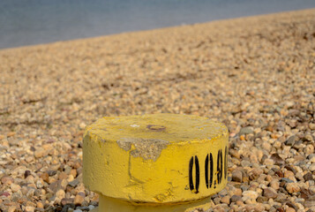 Yellow concrete pillar. Standing as a rock on the beach