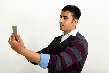 Portrait of handsome Indian man against white background