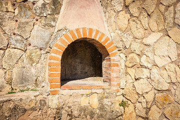 Traditional firewood oven on a stone wall