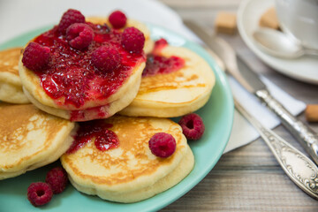 Delicious pancakes with raspberry jam, with fresh tea.