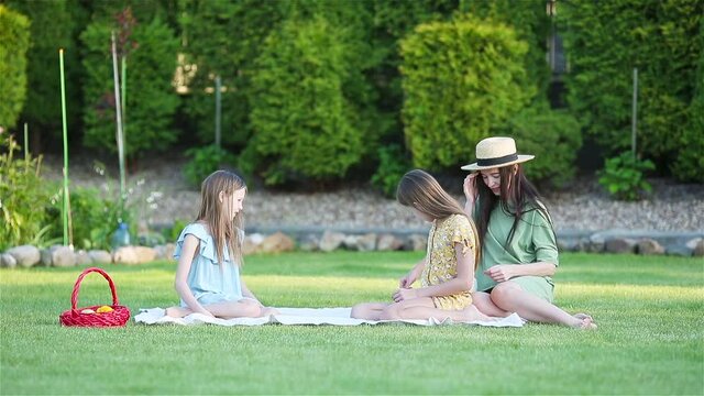 Happy mother and little daughers relax in suumer