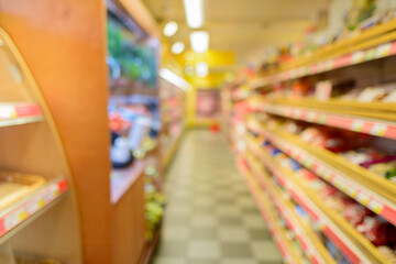Defocused supermarket aisle with shelves filled with grocery and checkered floor
