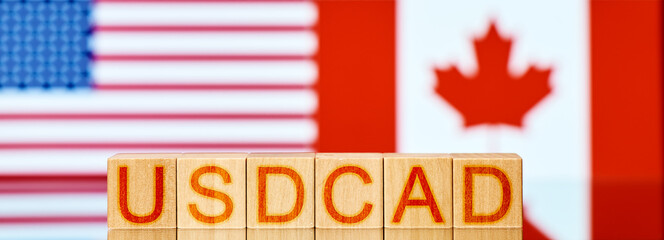 usd cad. wooden blocks with the inscription usd cad on the background of the usa and canadian flag