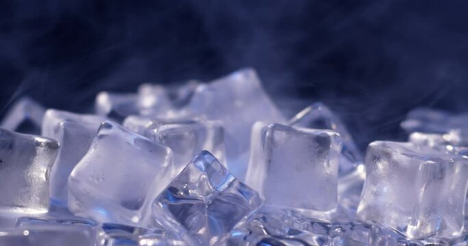 Macro shot of water ice cubes slowly melting and surrounded by vapor. 4k DCI footage