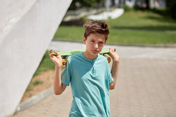 Face of handsome guy with a penny skate behind his back and an expressive look.