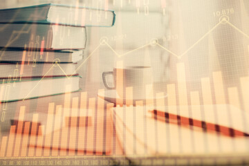 Double exposure of financial chart drawing and desktop with coffee and items on table background. Concept of forex market trading