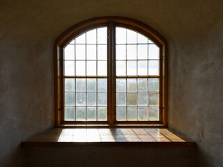 Closed wooden vintage window cemented on brick wall with natural view and sunlight streaming in