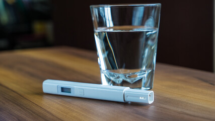 glass of water and water quality tester