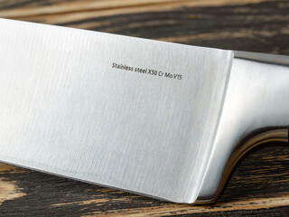 Close-up of steel marking on a professional chef knife blade. Modern kitchen utensils made of high carbon molybdenum vanadium steel.