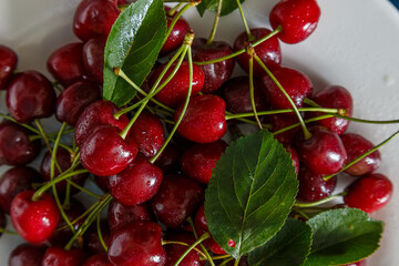 Fresh cherry on plate on wooden blue background.