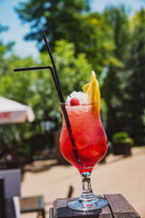 summer fruit cocktails in gentle female hands on the background of nature