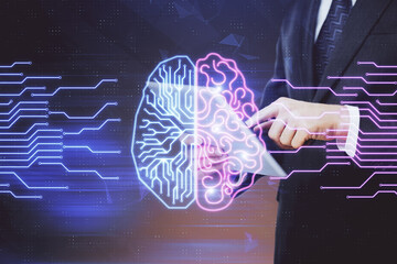 Double exposure of man's hand holding and using a digital device and brain hologram drawing. Data...
