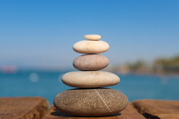 Fototapeta na wymiar Zen concept. Stack of stones on the beach. Blurred background. Concept of harmony, stability, life balance, and meditation.